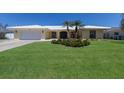 Charming single-story home with landscaped front yard, lush green lawn, and palm trees at 508 70Th St, Holmes Beach, FL 34217