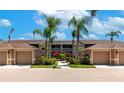 Exterior view of condo with a garage, mature landscaping, well-maintained complex under a partly cloudy blue sky at 5251 Mahogany Run Ave # 521, Sarasota, FL 34241