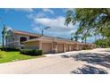 Exterior view featuring garage parking, mature landscaping, well maintained complex under a partly cloudy blue sky at 5251 Mahogany Run Ave # 521, Sarasota, FL 34241