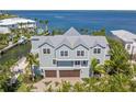 Beautiful coastal home featuring a three-car garage, lush landscaping, and stunning water views at 526 56Th St, Holmes Beach, FL 34217