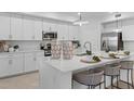 Modern kitchen with white cabinets, stainless steel appliances, and large island with seating at 5632 Summit Pointe Cir # 101, Bradenton, FL 34210