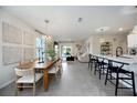 Bright living area adjacent to a dining room and kitchen with counter seating and patio access at 5800 Elegant Orchid Way, Sarasota, FL 34232