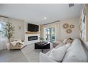 Bright living room features a fireplace, TV, and sliding glass doors to outdoor space at 5800 Elegant Orchid Way, Sarasota, FL 34232