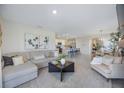 Open-concept living room showcases seamless flow to the kitchen, dining area, and neutral tones at 5800 Elegant Orchid Way, Sarasota, FL 34232