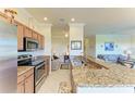 Charming kitchen with stainless steel appliances, wood cabinets, granite countertops, and a breakfast bar at 7005 River Hammock Dr # 402, Bradenton, FL 34212