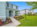 Charming home entrance with a cozy porch, decorative landscaping, and a welcoming gray door at 7107 58Th E Ter, Palmetto, FL 34221