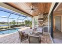 Screened patio with a summer kitchen, ceiling fan, comfortable seating, and a beautiful view of the pool and lake at 7113 Whittlebury Trl, Bradenton, FL 34202