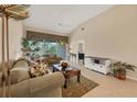Inviting living room boasts neutral tones, tile flooring, and sliding glass doors to a private balcony at 7115 Boca Grove Pl # 204, Lakewood Ranch, FL 34202