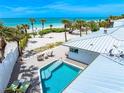 Aerial view of a private pool and deck with comfortable seating overlooking the beach at 722 N Manasota Key Rd, Englewood, FL 34223