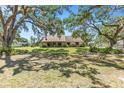 Quaint single-story home with a welcoming front porch and mature shade trees at 7407 91St E St, Palmetto, FL 34221