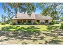 Charming single-story home with a covered porch, lush landscaping, and a well-manicured lawn at 7407 91St E St, Palmetto, FL 34221