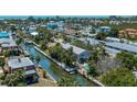 Stunning aerial view of a coastal home with a pool, dock, and canal access at 750 Tarawitt Dr, Longboat Key, FL 34228