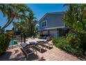 Lush backyard featuring a patio, pool, outdoor seating, and well-maintained landscaping at 750 Tarawitt Dr, Longboat Key, FL 34228