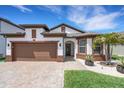 Charming single Gathering home with a two-car garage, beautiful brick paver driveway and manicured lawn at 7859 Yale Harbor Dr, Wesley Chapel, FL 33545