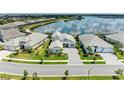 Daytime aerial view of the home with scenic lake and community views at 8067 Waterbend Trl, Sarasota, FL 34240