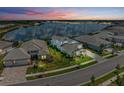Areal view of the home on a street by the lake at sunset at 8067 Waterbend Trl, Sarasota, FL 34240