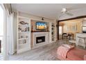 Stylish living room with built-in shelving, fireplace, and a ceiling fan at 850 S Tamiami Trl # 836, Sarasota, FL 34236