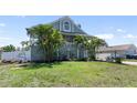 Charming two-story home featuring a lush green lawn and mature tropical landscaping at 861 Nectar Rd, Venice, FL 34293