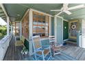 Cozy front porch with rocking chairs, ceiling fan, and views of the surrounding neighborhood at 861 Nectar Rd, Venice, FL 34293