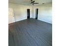 Spacious bedroom featuring modern gray flooring, a ceiling fan, and ample closet space at 8810 1/2 N Mulberry St, Tampa, FL 33604