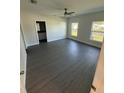 Bright bedroom with a ceiling fan, two windows, and dark floors at 8810 N Mulberry St, Tampa, FL 33604
