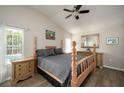 Bright main bedroom with a wood bed frame, ceiling fan, wood floors, and backyard pool view at 11274 Beebalm Cir, Lakewood Ranch, FL 34202