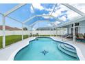 Inviting screened-in pool with tile accents, lounge chairs, and spacious patio for outdoor relaxation at 11895 Claremont Dr, Port Charlotte, FL 33981