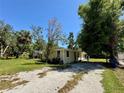 Lovely single-story home with a stucco exterior, complemented by well-established trees and a gravel driveway at 1317 Venetia St, Nokomis, FL 34275