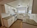 Bright kitchen featuring white cabinets, granite countertops, and modern appliances at 1317 Venetia St, Nokomis, FL 34275