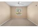 Neutral bedroom with carpet flooring, a ceiling fan, and a window offering natural light and views of the outdoors at 1363 New Forest Ln, Osprey, FL 34229