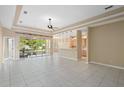 Spacious living room featuring tile floors, a tray ceiling, and sliding glass doors leading to an outdoor patio at 1363 New Forest Ln, Osprey, FL 34229