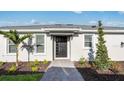 Inviting front entrance featuring a black front door, sidelight, and well-maintained landscaping at 16202 Isola Pl, Bradenton, FL 34211