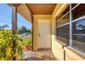 Inviting front entrance with a white door, a tiled porch, and decorative plants, welcoming guests at 2707 Vinson Ave, Sarasota, FL 34232