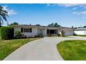 Charming single-story home boasting a well-manicured lawn and a winding driveway leading to an attached garage at 3130 Key Way, Sarasota, FL 34239
