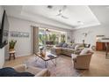 Open living room with cozy seating, neutral decor, tile floors, and sliding glass doors to the lanai at 358 River Enclave Ct, Bradenton, FL 34212