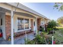 Close-up of a charming brick home featuring a cozy front porch and colorful landscaping at 4243 Maceachen Blvd, Sarasota, FL 34233