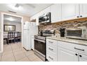 Well-lit kitchen featuring white cabinets, stainless steel appliances, and stylish tile backsplash at 432 Crosby Ct, Sarasota, FL 34237
