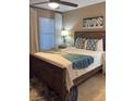 Bedroom with a queen bed, a painting of flowers, blue throw blanket, two side tables with lamps at 4510 El Conquistador Pkwy # 105, Bradenton, FL 34210