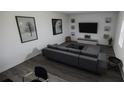 Modern living room with gray sectional couch, TV, decorative wall art, and hardwood floors at 4610 Hawthorn Avenue, Parrish, FL 34219