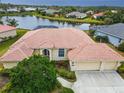Beautiful aerial view of home with a terracotta roof, lush backyard, and scenic lake views at 4613 Sweetmeadow Cir, Sarasota, FL 34238