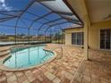 Inviting screened-in pool with scenic lake view, brick pavers, and seamless access to the home's interior at 4613 Sweetmeadow Cir, Sarasota, FL 34238
