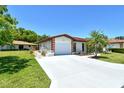 Inviting single-story home featuring a long driveway, a two-car garage, and a beautifully maintained lawn at 6007 Vivienda Dr # 29, Bradenton, FL 34207