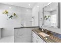 Bright bathroom featuring a glass shower, modern fixtures, and white marble patterned tile at 6532 Copper Ridge Trl, Bradenton, FL 34201