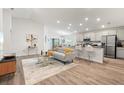 Bright living room and open kitchen featuring stylish furniture, decor, and wood floors at 6708 162Nd E Pl, Parrish, FL 34219