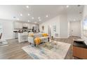 Open-concept living room featuring modern decor, wood floors, and ample natural light at 6708 162Nd E Pl, Parrish, FL 34219