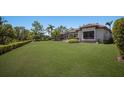 Expansive backyard featuring lush green lawn, mature trees, and meticulously manicured hedges at 7011 Belmont Ct, Lakewood Ranch, FL 34202