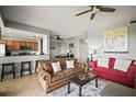 Bright living room with a partial view of the kitchen, a ceiling fan, and a combination of tile floors and neutral walls at 7607 Grand Estuary Trl # 302, Bradenton, FL 34212