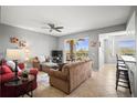 Comfortable living area with neutral walls, tile flooring, a ceiling fan, and sliding glass doors to the balcony at 7607 Grand Estuary Trl # 302, Bradenton, FL 34212