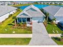 Aerial view of a lovely home with a paver driveway, tropical landscaping, and a serene lake backdrop at 8107 Slipway Dr, Sarasota, FL 34240
