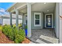 Cozy front porch with stylish chairs, lush plants, and a welcoming entrance with blue door at 8107 Slipway Dr, Sarasota, FL 34240